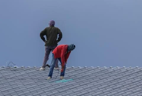 Workers are installing building roofs. Stock Photos