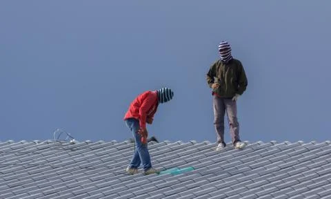 Workers are installing building roofs. Stock Photos