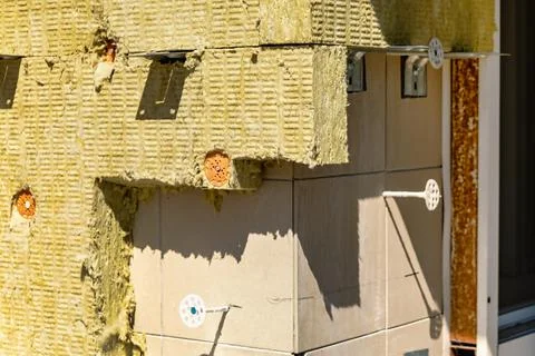 Workers are installing insulation on a building's exterior wall. The wall h.. Stock Photos