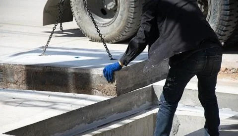 Workers are installing a large concrete manhole cover. Foto stock