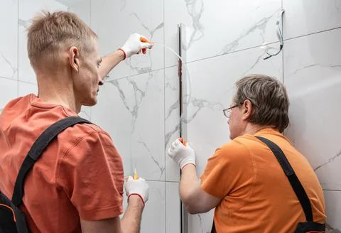 Workers are installing a silicone gasket seal in the metal profile of the sho Stock Photos