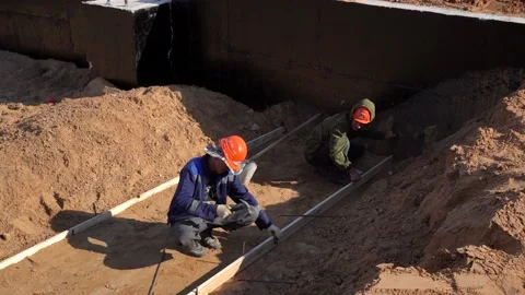 Workers are installing the wooden formwork for pouring concrete base Stock Footage 238510561