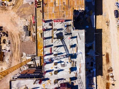 Workers are involved in a construction project. Cranes are visible and wooden Stock Photos