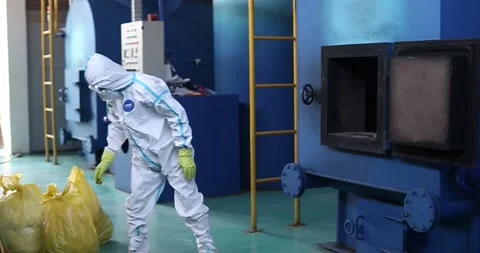 Workers are loading garbage into the incinerator by wearing protective Stock Footage 170927070