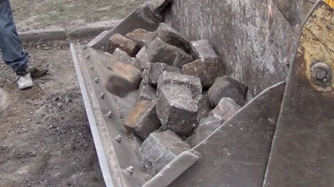 Workers are loading granite stones from the road surface into the excavator 스톡 동영상 148815266