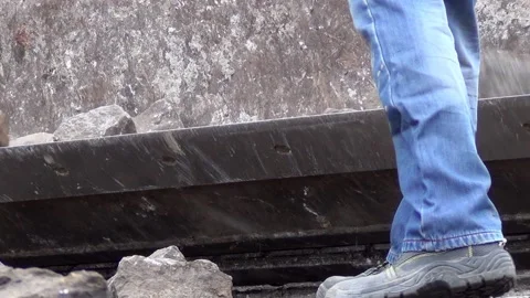 Workers are loading granite stones from the road surface into the excavator 스톡 동영상 148815752