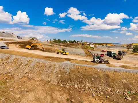 Workers are operating various types of machinery in a granite quarry. Trucks  Stock Photos