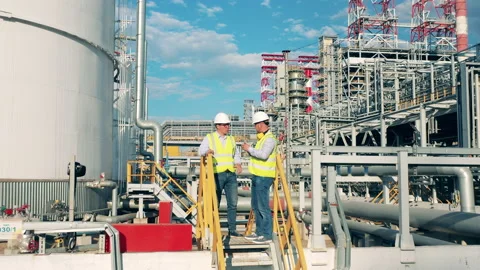 Workers are planning a project on the premises of the oil refinery Stock Footage 157213885