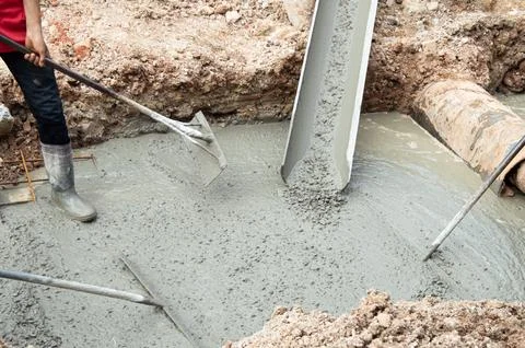 Workers are pouring cement on the construction site. Stock Photos