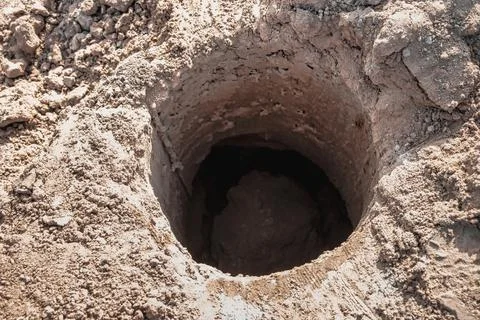 Workers are preparing a borehole in the ground for the installation of a pile Stock Photos