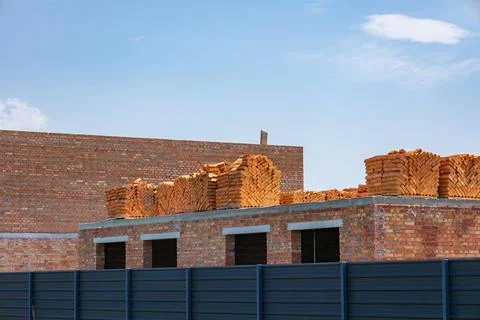 Workers are preparing a building structure with numerous bricks neatly pile.. Stock Photos