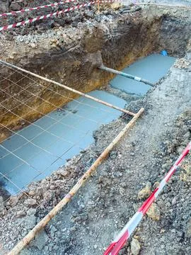 Workers are preparing for a construction project. A trench has been dug into  Stock Photos
