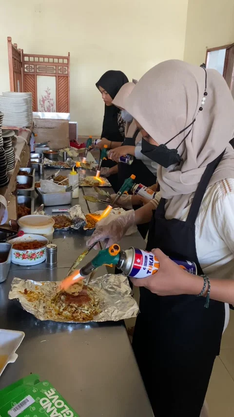 Workers are preparing food called "mie bakar" or roasted noodles Stock Footage 293039557