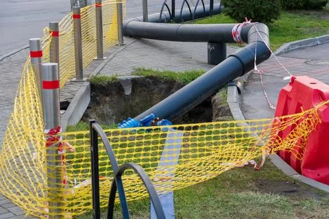 Workers are replacing old water pipes on the street, using digging equipmen.. Stock Photos