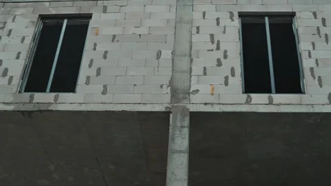 Workers are seen completing construction on a new building, showcasing exposed Vidéo 339095744