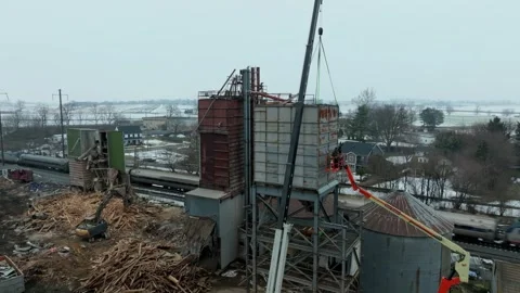 Workers are seen taking down a large structure in a rural setting. Equipment is Stock Footage 345686295