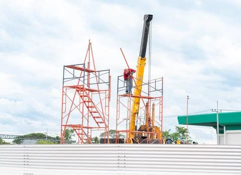 Workers are setting up scaffolding for the construction of the metal sheet .. Stock Photos
