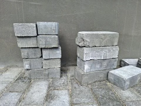 Workers are stacking grey slabs at the construction area Stock Photos