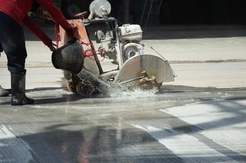 Workers are using a concrete road cutter. Stock Photos