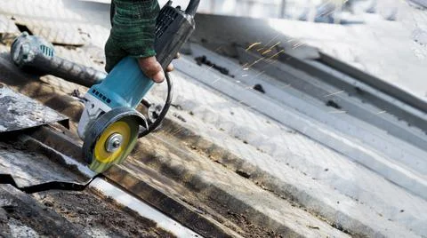Workers are using grinding stones, cutting, fixing steel roofs. Stock Photos