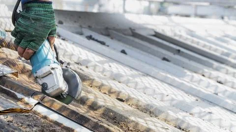 Workers are using grinding stones, cutting, fixing steel roofs. Stock Photos