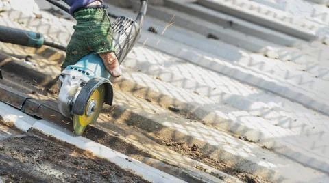 Workers are using grinding stones, cutting, fixing steel roofs. Stock Photos