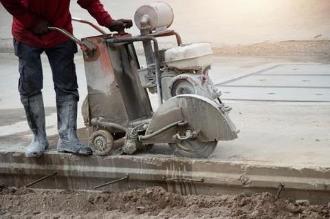Workers are using machinery to cut concrete floors. Stock Photos