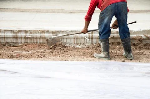 Workers are using shovels to level the ground before pouring concrete at a .. Stock Photos