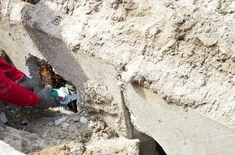 Workers are using steel cutting machines in a narrow space. Stock Photos