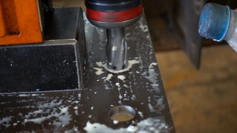 Workers are using a steel drill, with pouring coolant on a drill. Video stock 94554760