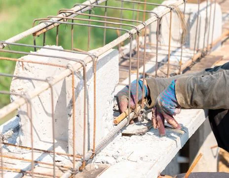 Workers are using steel wire to bind steel bars. Stock Photos