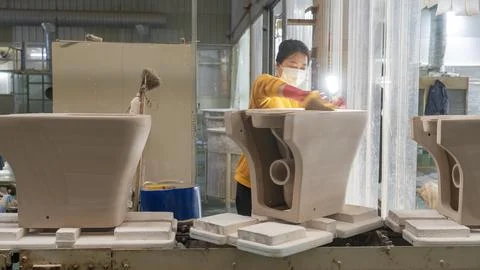 Workers are working intensively on the ceramic bathroom production line in .. Stock Photos