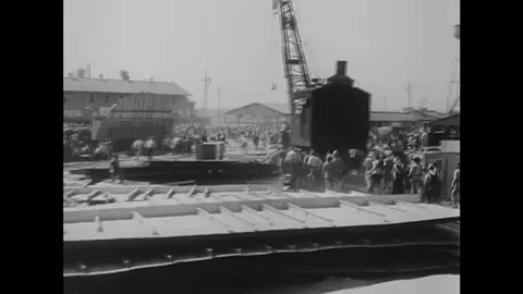 Workers arrive at a dry dock and shipbuilding company to repair warships and Stock Footage 106033384