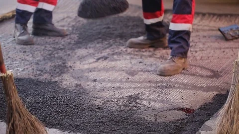 Workers asphalt a damaged section of the road Stock Footage 74136190
