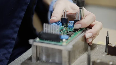 Workers assemble the appliance. Installs components on the wiring diagram Stock Footage 108950372