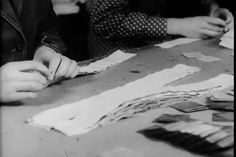 Workers assemble the different plates in stripes and insert it in vest - 1945 Stock Footage 99786834