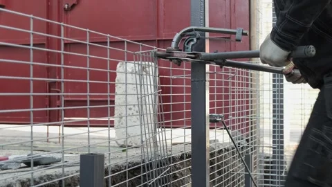 Workers assemble the fence structure using hand tools. Stock Footage 240179697