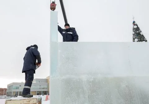 Workers assemble ice blocks on the frame of a wooden slide Foto stock