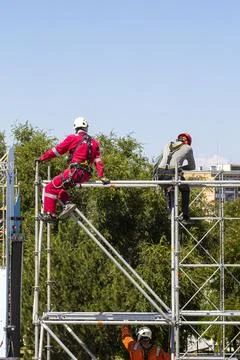 Workers assemble a metal structure at height Stock Photos