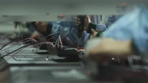 Workers assembling the back cover of a household TV on a factory assembly line Stock Footage 162366441