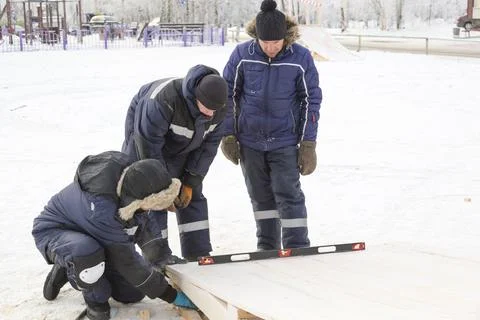 Workers assembling the frame of a wooden slide 스톡 사진