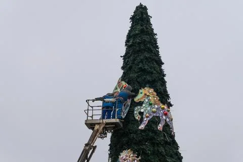 Workers assembling a large artificial christmas tree in urban square. Urban.. Stock Photos