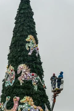 Workers assembling a large artificial christmas tree in urban square. Urban.. Stock Photos