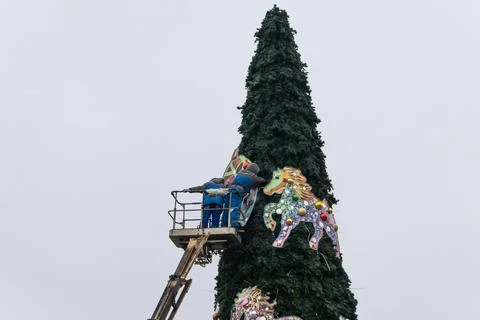 Workers assembling a large artificial christmas tree in urban square. Urban.. Stock Photos
