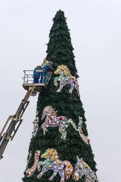 Workers assembling a large artificial christmas tree in urban square. Urban.. Stock Photos