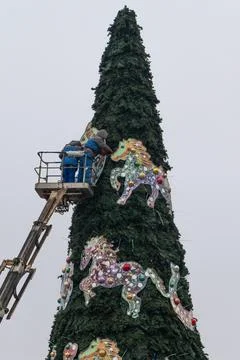Workers assembling a large artificial christmas tree in urban square. Urban.. Fotos Stock