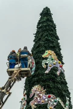Workers assembling a large artificial christmas tree in urban square. Urban.. Stock Photos
