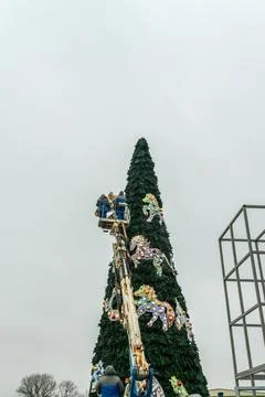 Workers assembling a large artificial christmas tree in urban square. Urban.. Stockfoto's