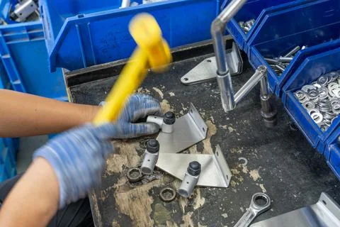 Workers assembling metal hardware connectors hammering with mallets Stock Photos