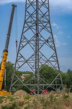 Workers assembling a power pole at high altitude Stock Photos